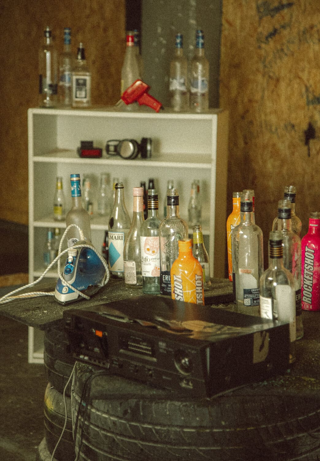 Rage room setup with bottles and white cabinet